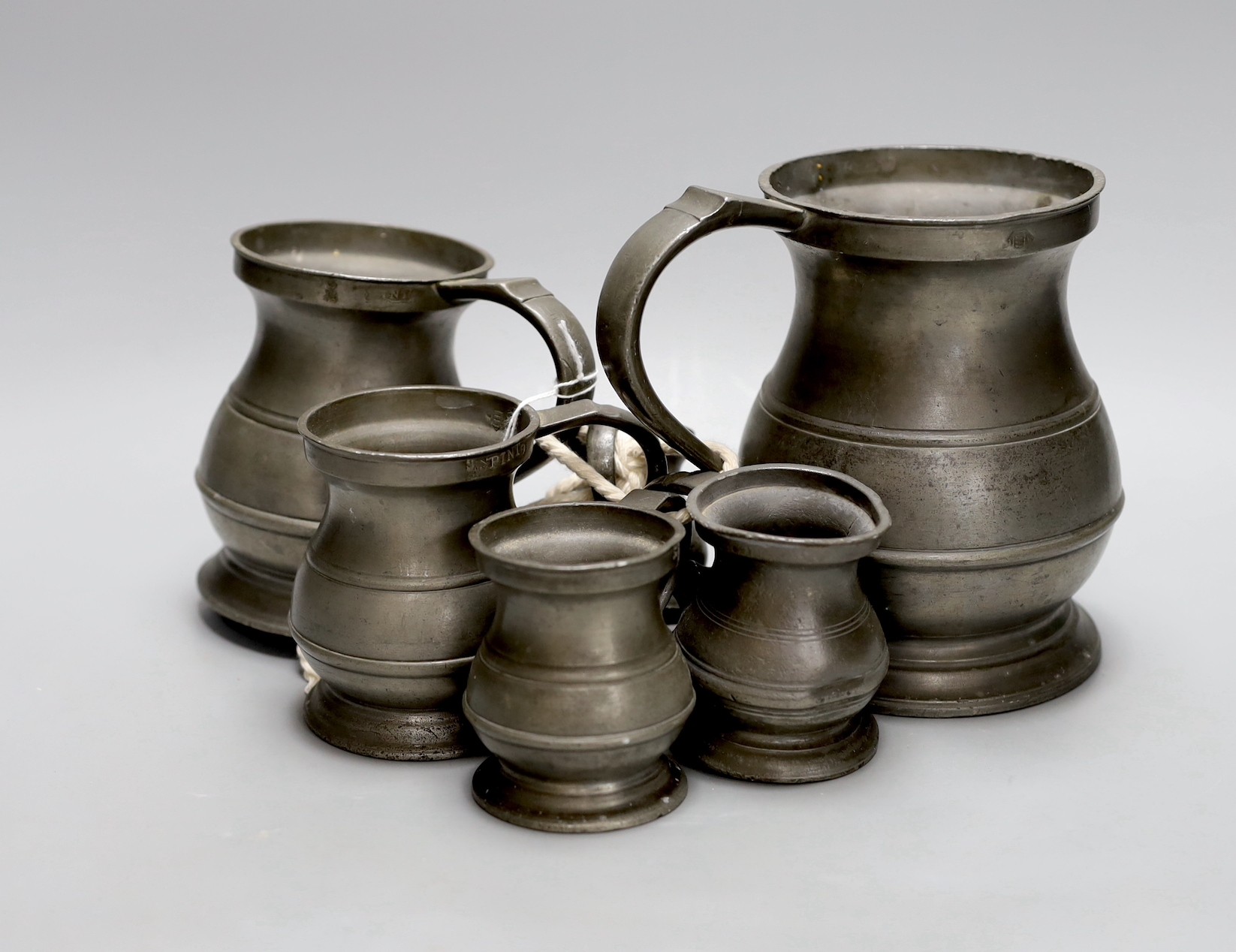 A set of six graduated pewter tankards, tallest 16 cms high